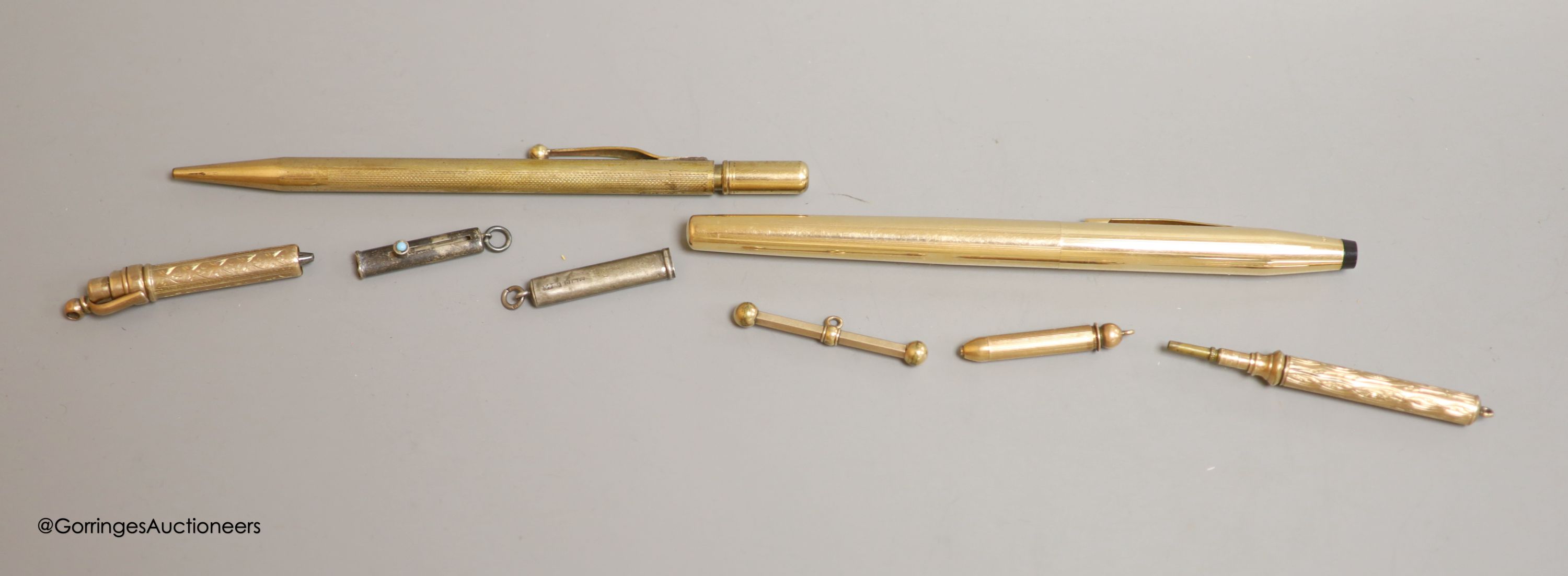 Rolled gold pens and pencils including a T-bar and two silver cased pencils.